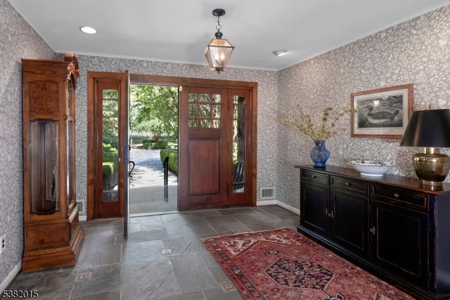 a view of a hallway with furniture and a chandelier