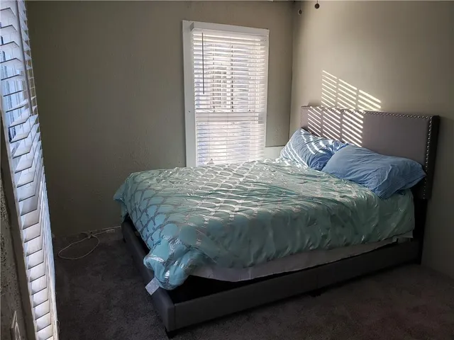 a bed sitting in a bedroom next to a window