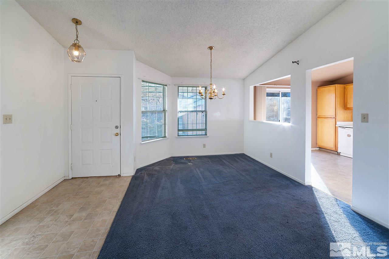 6314 Moon Ridge Terrace Reno, NV 89523 - Photo 6 of 24 an empty room with windows and chandelier