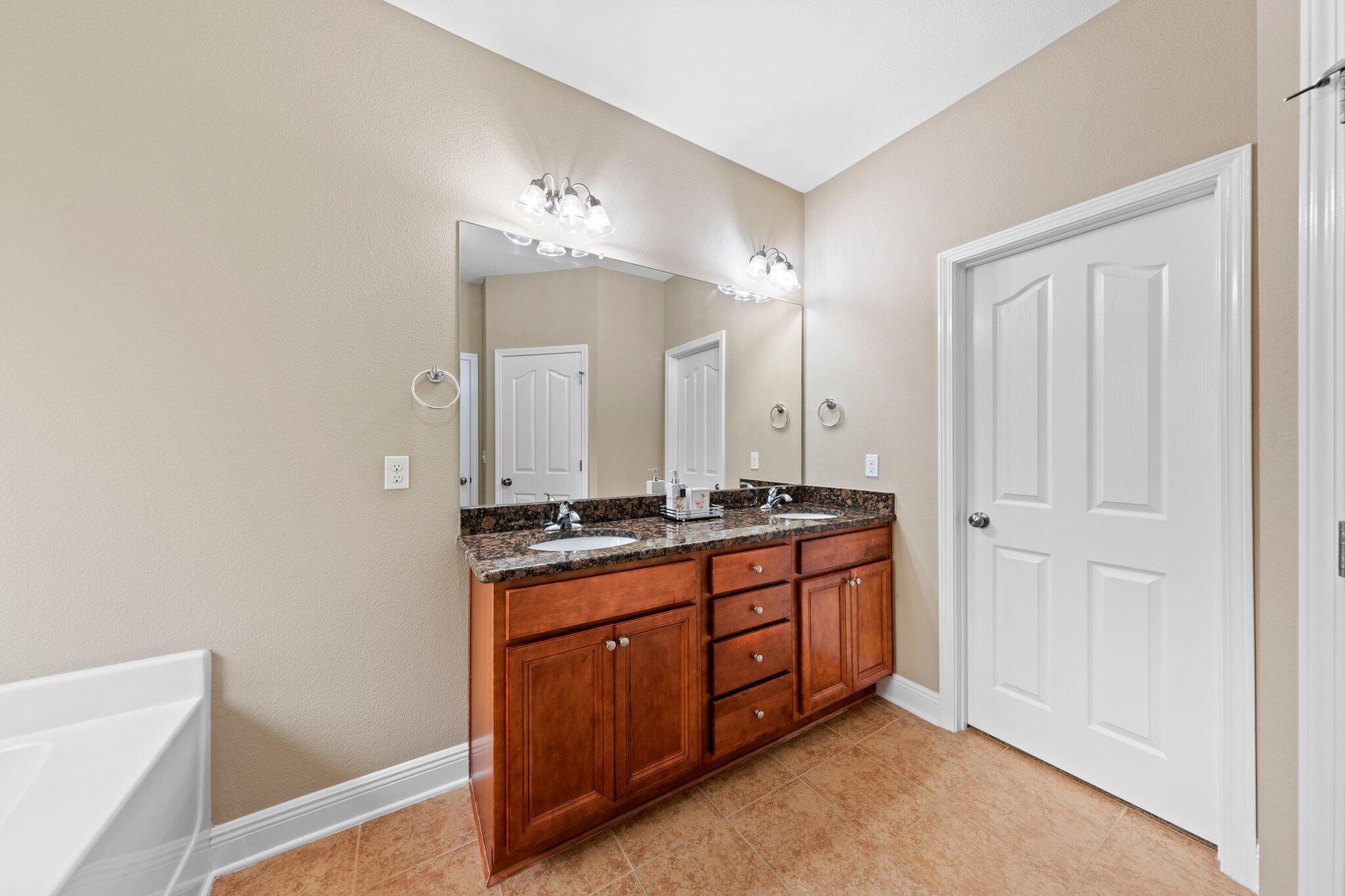 613 Red Fern Road Crestview, FL 32536 - Photo 15 of 39 a spacious bathroom with a double vanity sink and a mirror