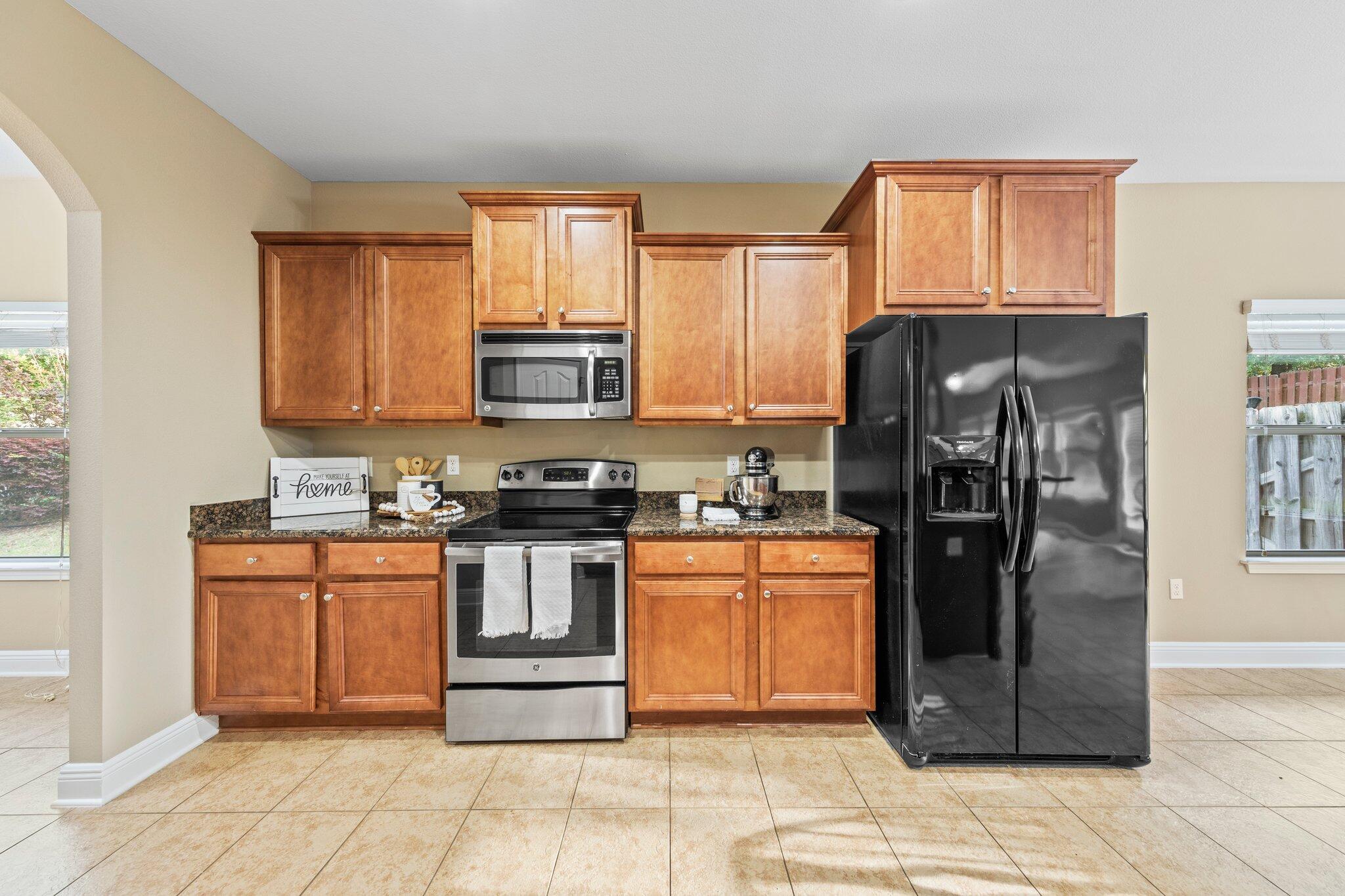 613 Red Fern Road Crestview, FL 32536 - Photo 29 of 39 a kitchen with stainless steel appliances granite countertop a stove top oven a refrigerator and a sink