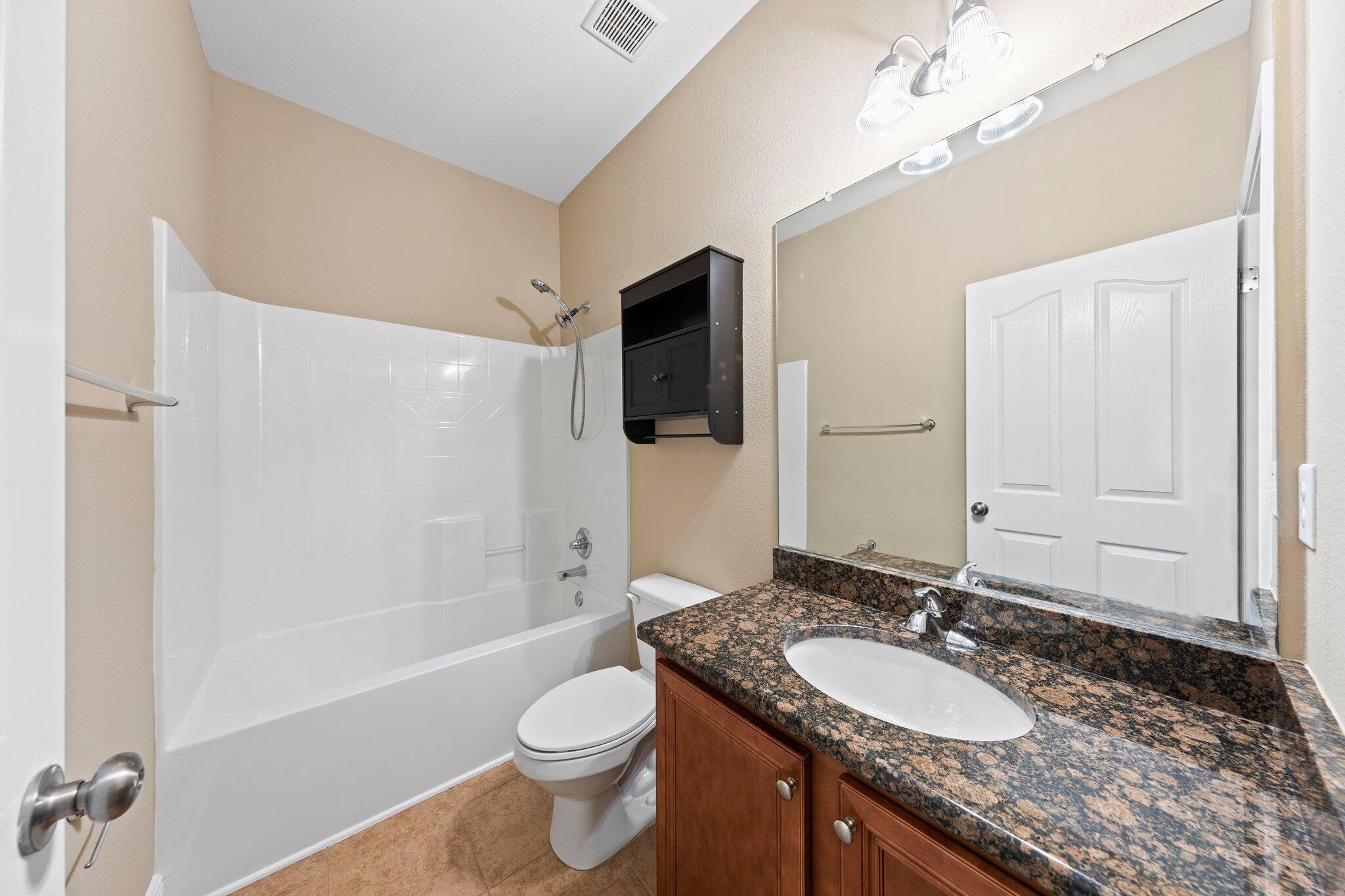613 Red Fern Road Crestview, FL 32536 - Photo 10 of 39 a bathroom with a granite countertop sink a toilet a mirror and shower