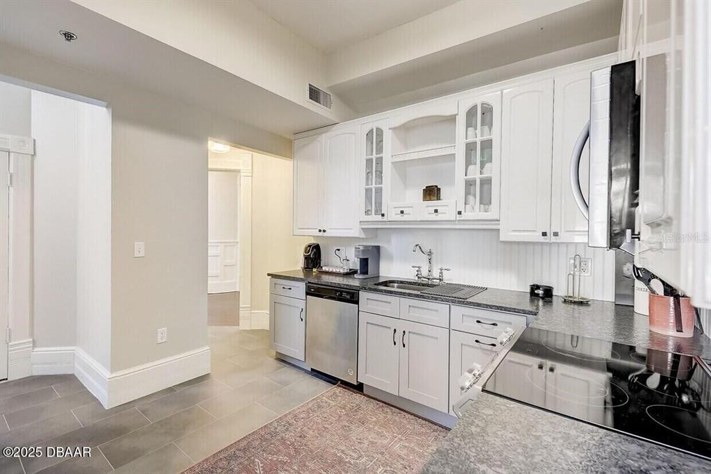 404 South Ridgewood Avenue Daytona Beach, FL 32114 - Photo 13 of 53 a kitchen with stainless steel appliances granite countertop a sink and cabinets with wooden floor