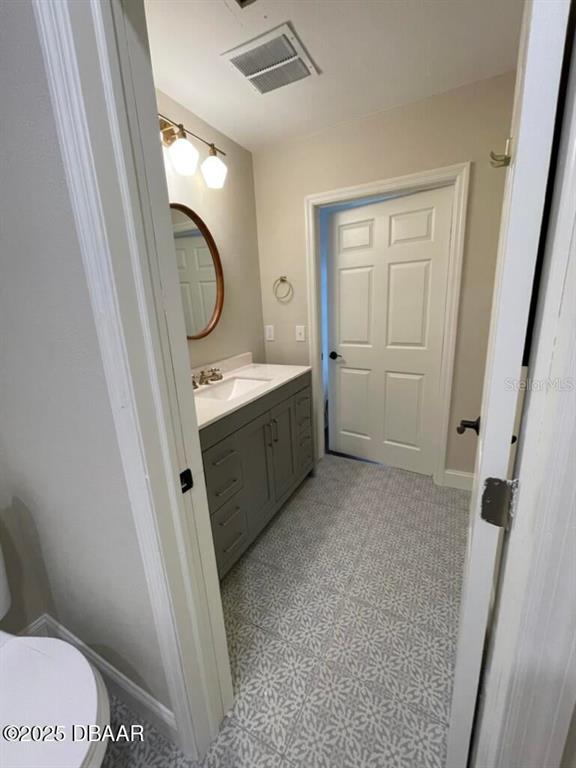 404 South Ridgewood Avenue Daytona Beach, FL 32114 - Photo 21 of 53 a bathroom with a sink a toilet and a mirror