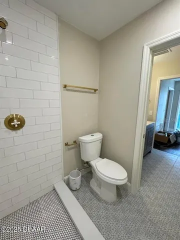 a white toilet sitting next to a bathroom sink and vanity