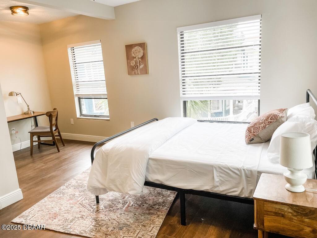 404 South Ridgewood Avenue Daytona Beach, FL 32114 - Photo 29 of 53 a bedroom with a bed and wooden floor