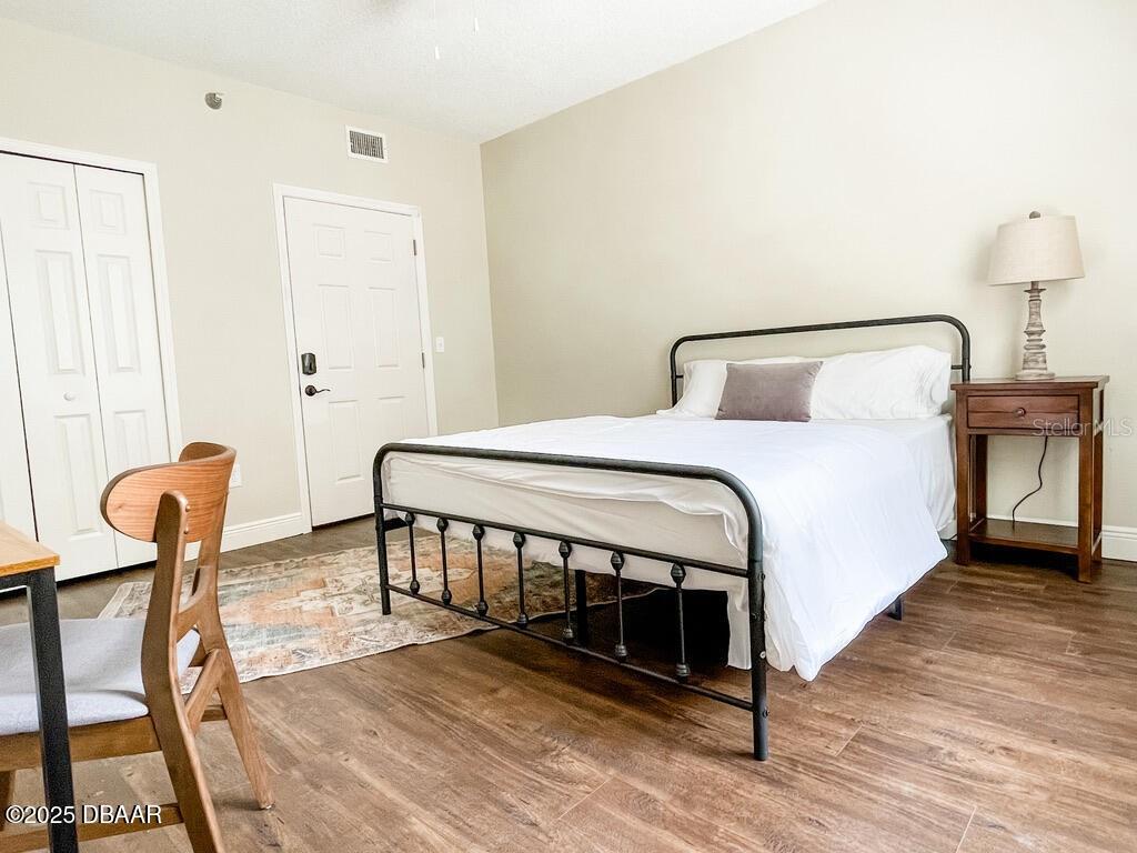 404 South Ridgewood Avenue Daytona Beach, FL 32114 - Photo 30 of 53 a bedroom with a bed a lamp and wooden floor