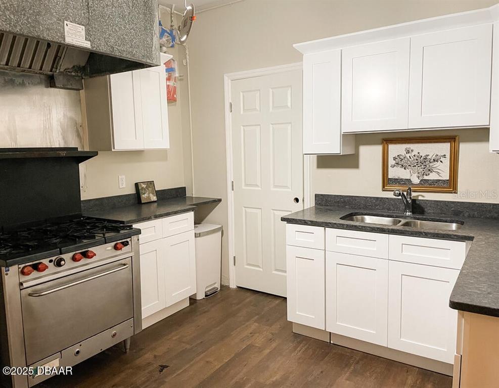 404 South Ridgewood Avenue Daytona Beach, FL 32114 - Photo 32 of 53 a kitchen with granite countertop a sink a stove and cabinets