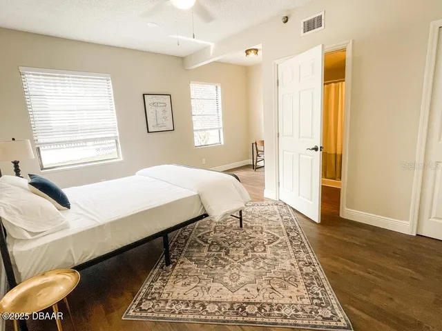 a bedroom with a bed and wooden floor