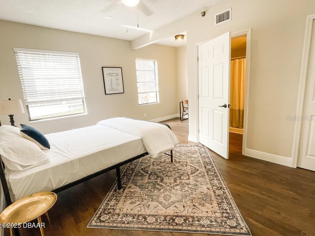404 South Ridgewood Avenue Daytona Beach, FL 32114 - Photo 39 of 53 a bedroom with a bed and wooden floor