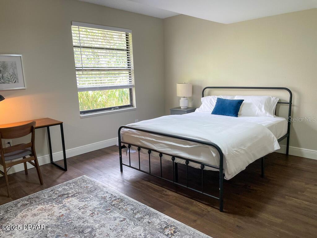 404 South Ridgewood Avenue Daytona Beach, FL 32114 - Photo 43 of 53 a bedroom with a bed a dresser and wooden floor
