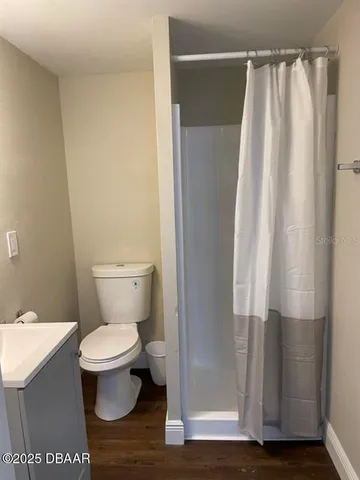 a bed sitting in a bedroom next to a window with wooden floor