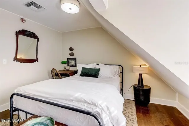 a bedroom with a bed and wooden floor