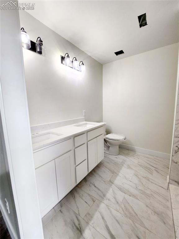 704 Elm Street Pueblo, CO 81004 - Photo 15 of 22 a bathroom with a sink a toilet and a mirror