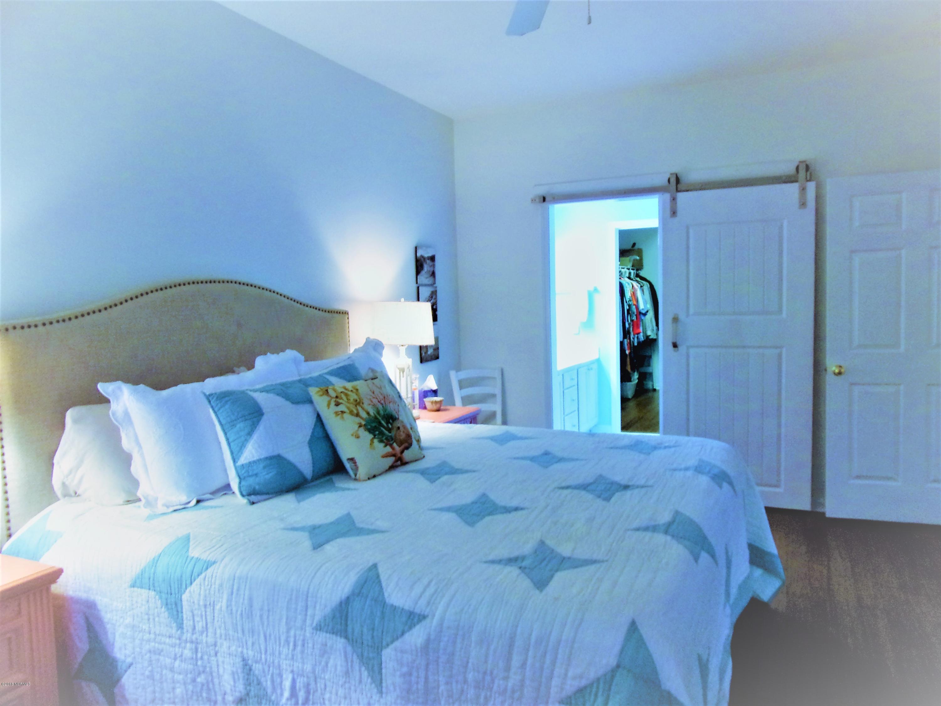 116 Rice Mill Circle, Unit 1 Sunset Beach, NC 28468 - Photo 9 of 24 master bedroom with barn door to masterb