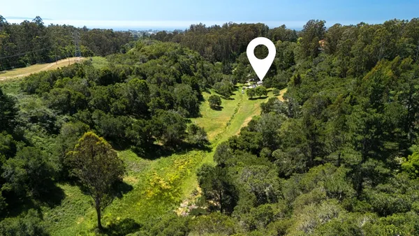 a aerial view of a house with a swimming pool and a yard