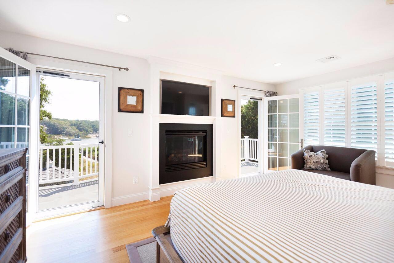 374 Monomoscoy Road Mashpee, MA 02649 - Photo 23 of 29 a bedroom with a balcony a bed and a television