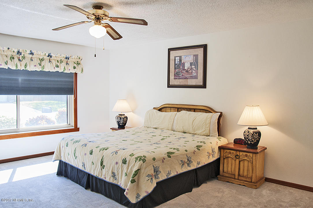 145 Tanager Road St. Augustine, FL 32086 - Photo 14 of 43 a bedroom with a bed paintings on the wall and a large window