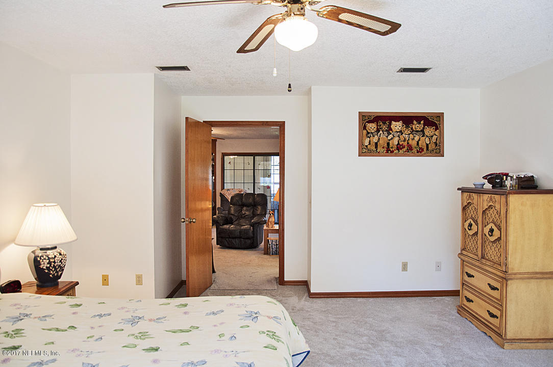 145 Tanager Road St. Augustine, FL 32086 - Photo 16 of 43 a bedroom with a bed and a chandelier
