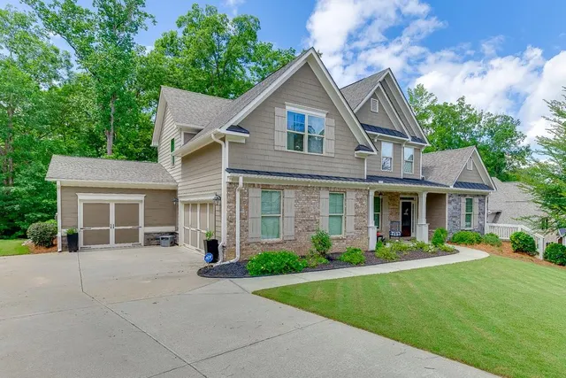 a front view of a house with a yard and potted plants