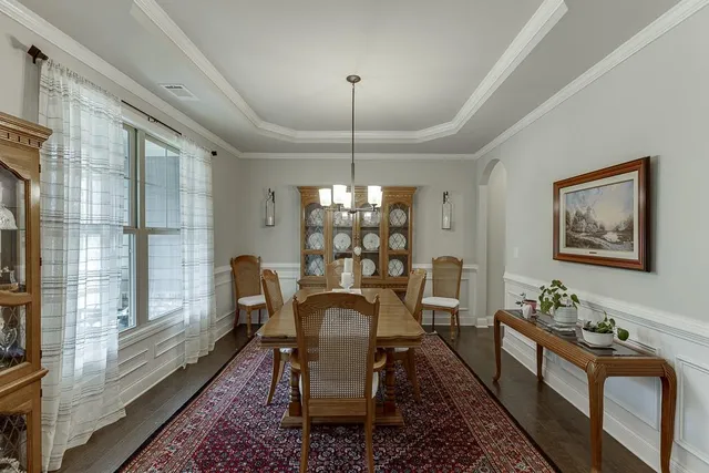 a dining room with furniture a chandelier and wooden floor