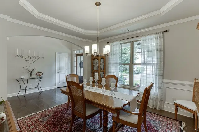a view of a dining room with furniture wooden floor and chandelier