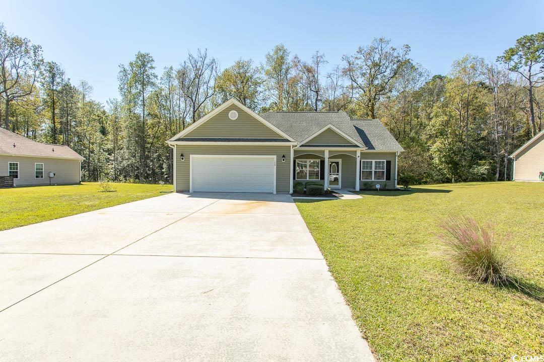 126 Allsbrook Road Loris, SC 29569 - Photo 2 of 30 View of front of house featuring a front yard, covered porch, driveway, a garage, and roof with shingles