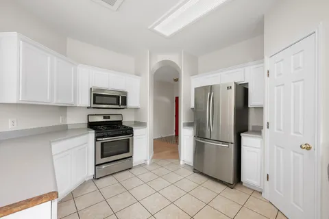 a kitchen with stainless steel appliances granite countertop a refrigerator and a stove top oven