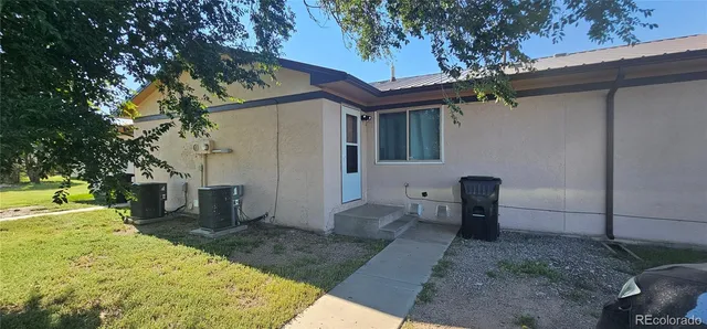 a backyard of a house with table and chairs