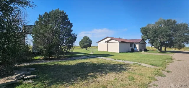 a view of a big house with a big yard and large trees