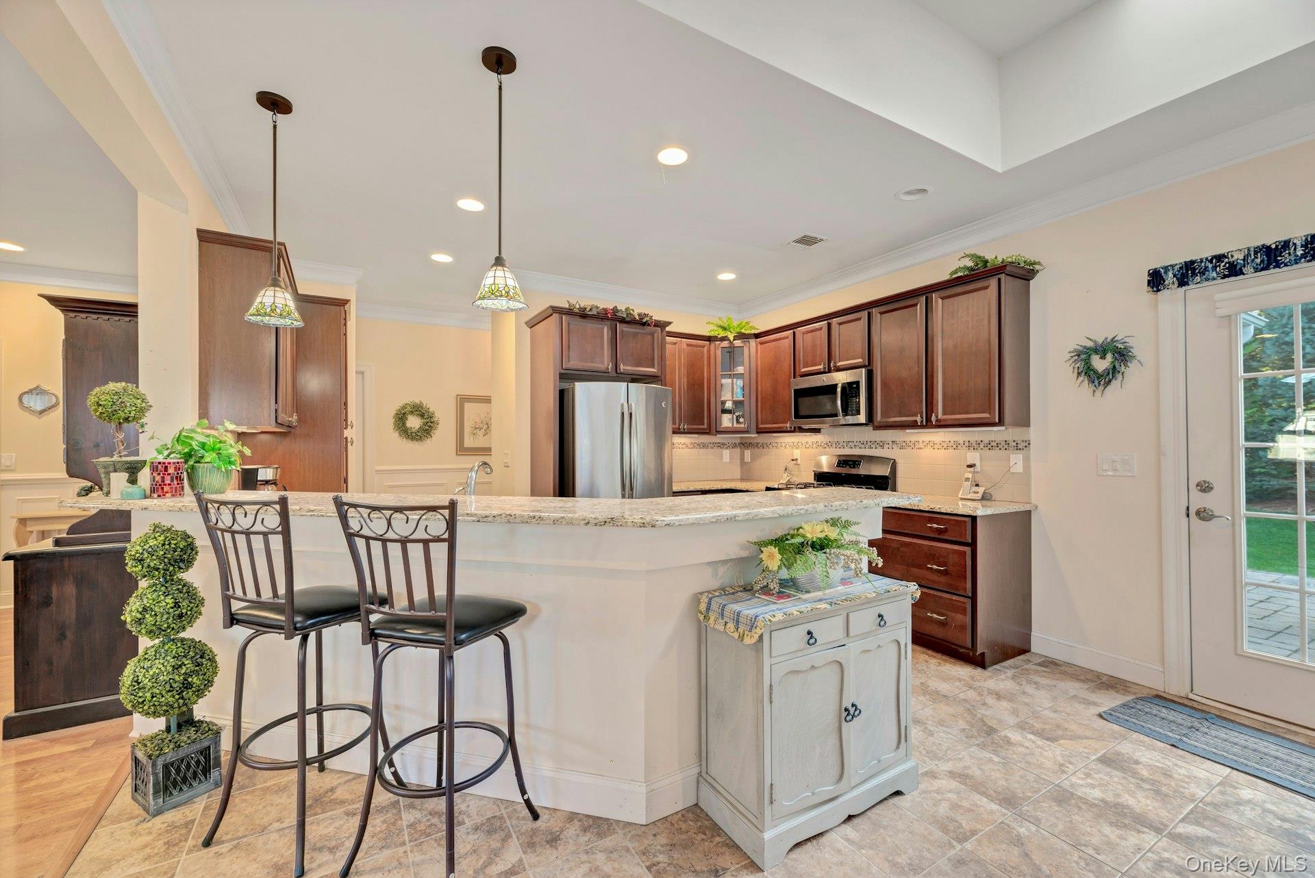 159 Stoneleigh Drive Riverhead, NY 11901 - Photo 14 of 24 Kitchen with a breakfast bar area, light stone countertops, appliances with stainless steel finishes, recessed lighting, and decorative light fixtures