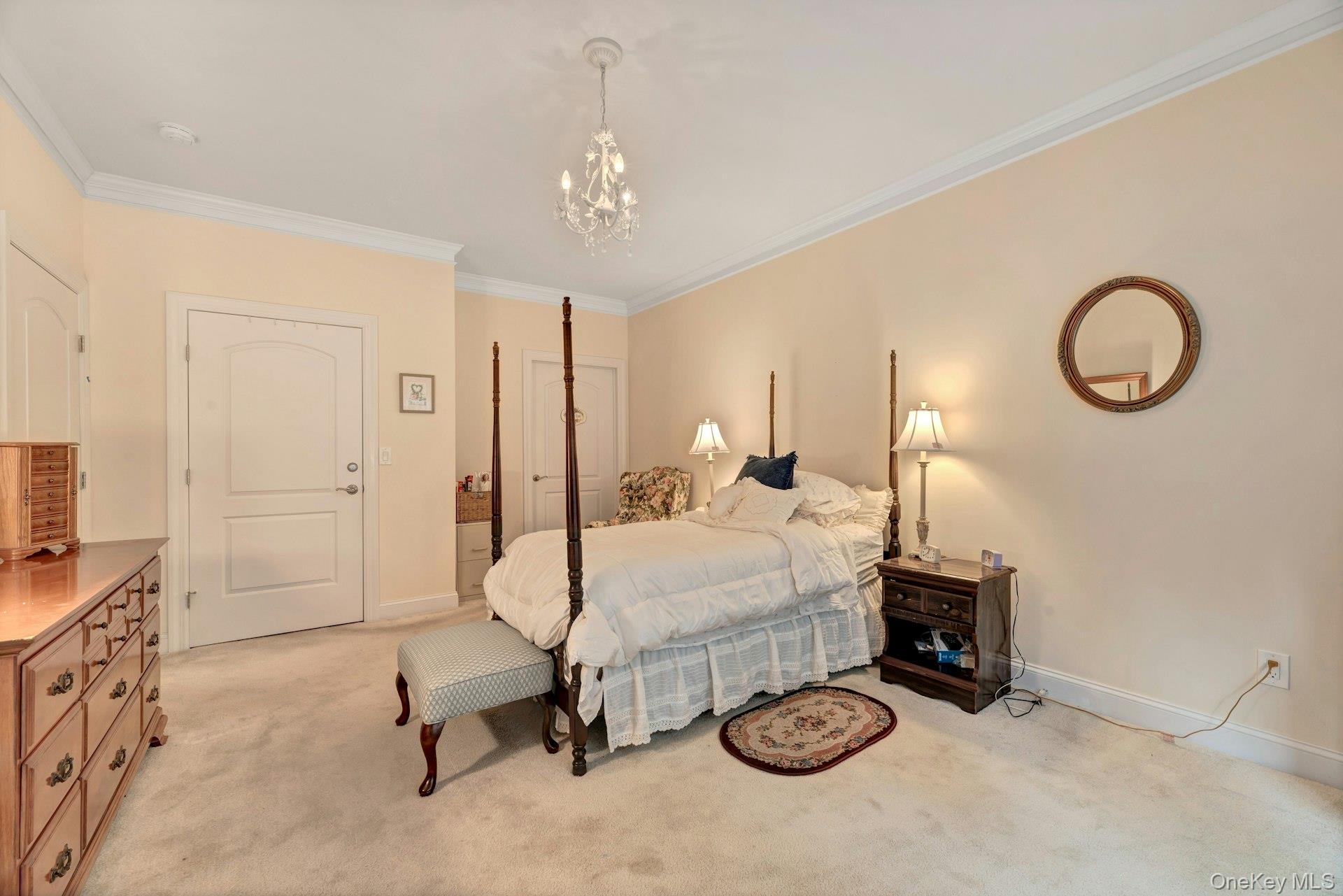 159 Stoneleigh Drive Riverhead, NY 11901 - Photo 20 of 24 Bedroom featuring crown molding, light carpet, and a chandelier
