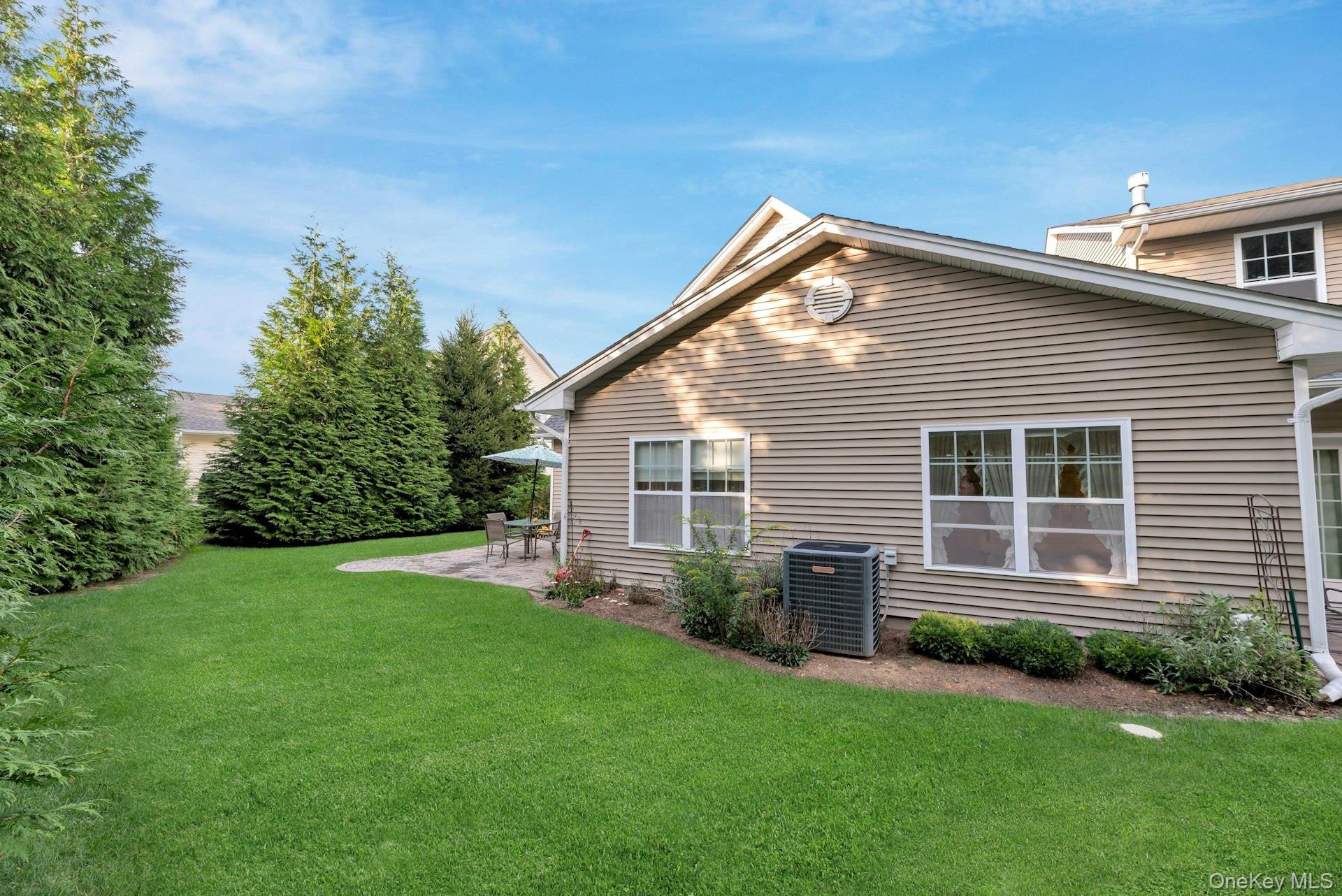 159 Stoneleigh Drive Riverhead, NY 11901 - Photo 7 of 24 Back of property featuring a patio area and a lawn