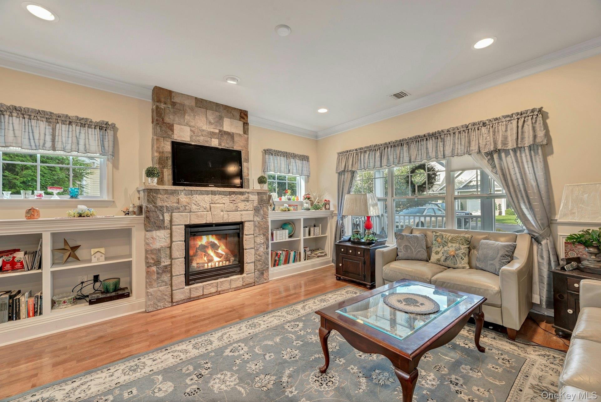 159 Stoneleigh Drive Riverhead, NY 11901 - Photo 10 of 24 Living room with ornamental molding, a fireplace, light wood-style flooring, and recessed lighting