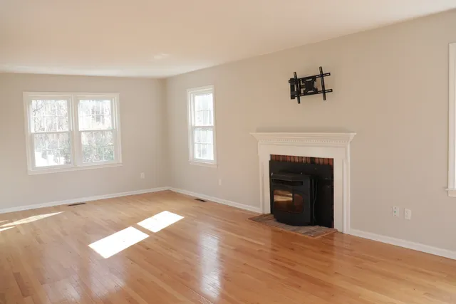 a view of an empty room with window and fire place
