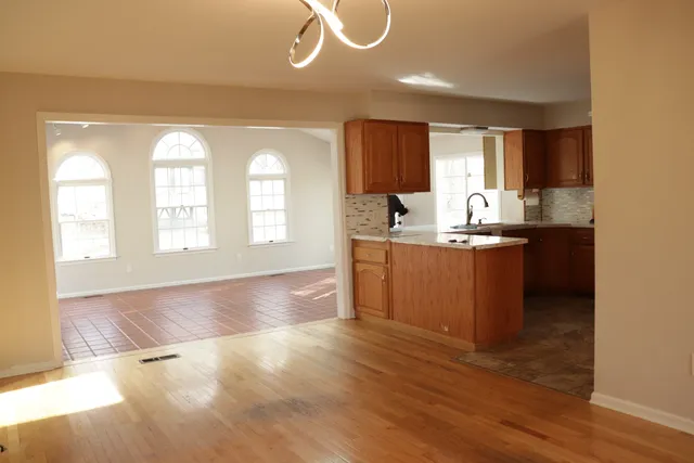 a kitchen with stainless steel appliances granite countertop a sink a stove cabinets and wooden floor