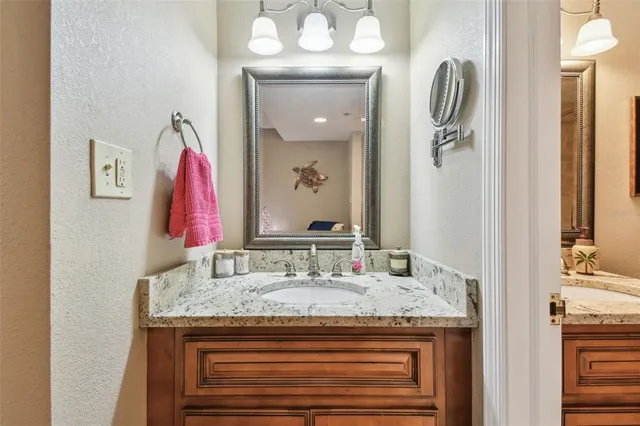 a bathroom with a granite countertop sink and a mirror