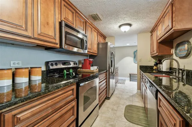 a kitchen with stainless steel appliances granite countertop a stove and a sink