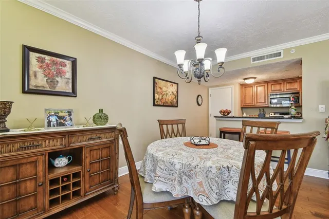 a view of a dining room with furniture a chandelier and wooden floor