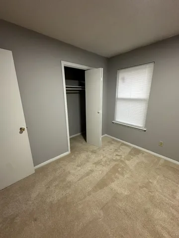 an empty room with windows and closet