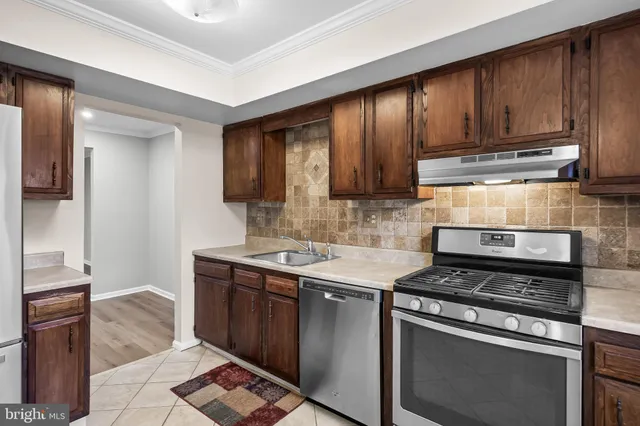 a kitchen with stainless steel appliances granite countertop a refrigerator a sink and a stove