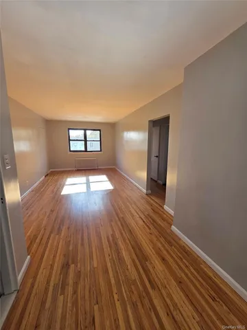 a view of a room with wooden floors and window