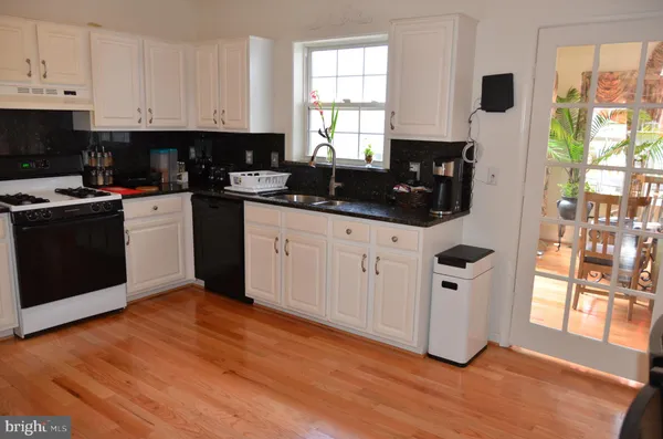 a kitchen with granite countertop a sink cabinets and wooden floor