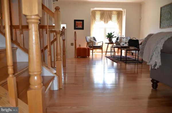 a living room with couches and dinning table with wooden floor