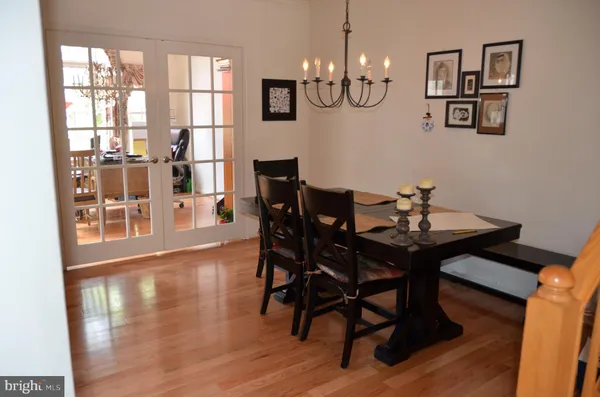 a view of a dining room with furniture a chandelier and wooden floor