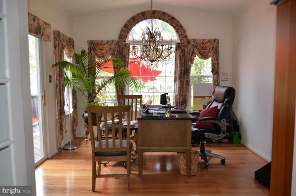 a view of a dining room with furniture a chandelier and wooden floor