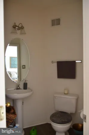a bathroom with a toilet a sink and mirror