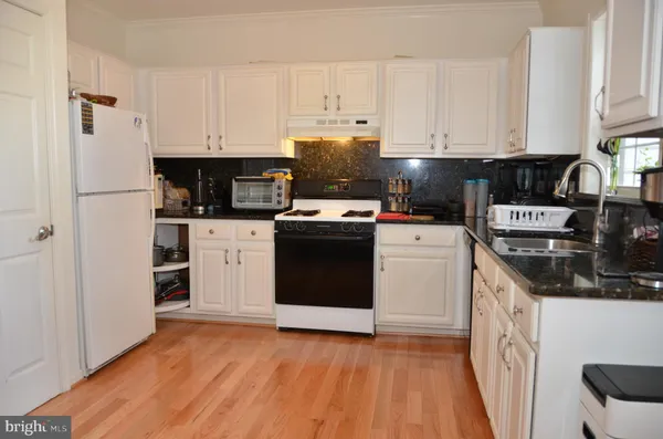 a kitchen with a white cabinets and white appliances