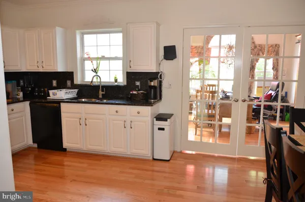 a kitchen with stainless steel appliances wooden floors and sink