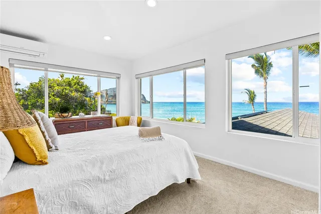 a bedroom with large window and a bed